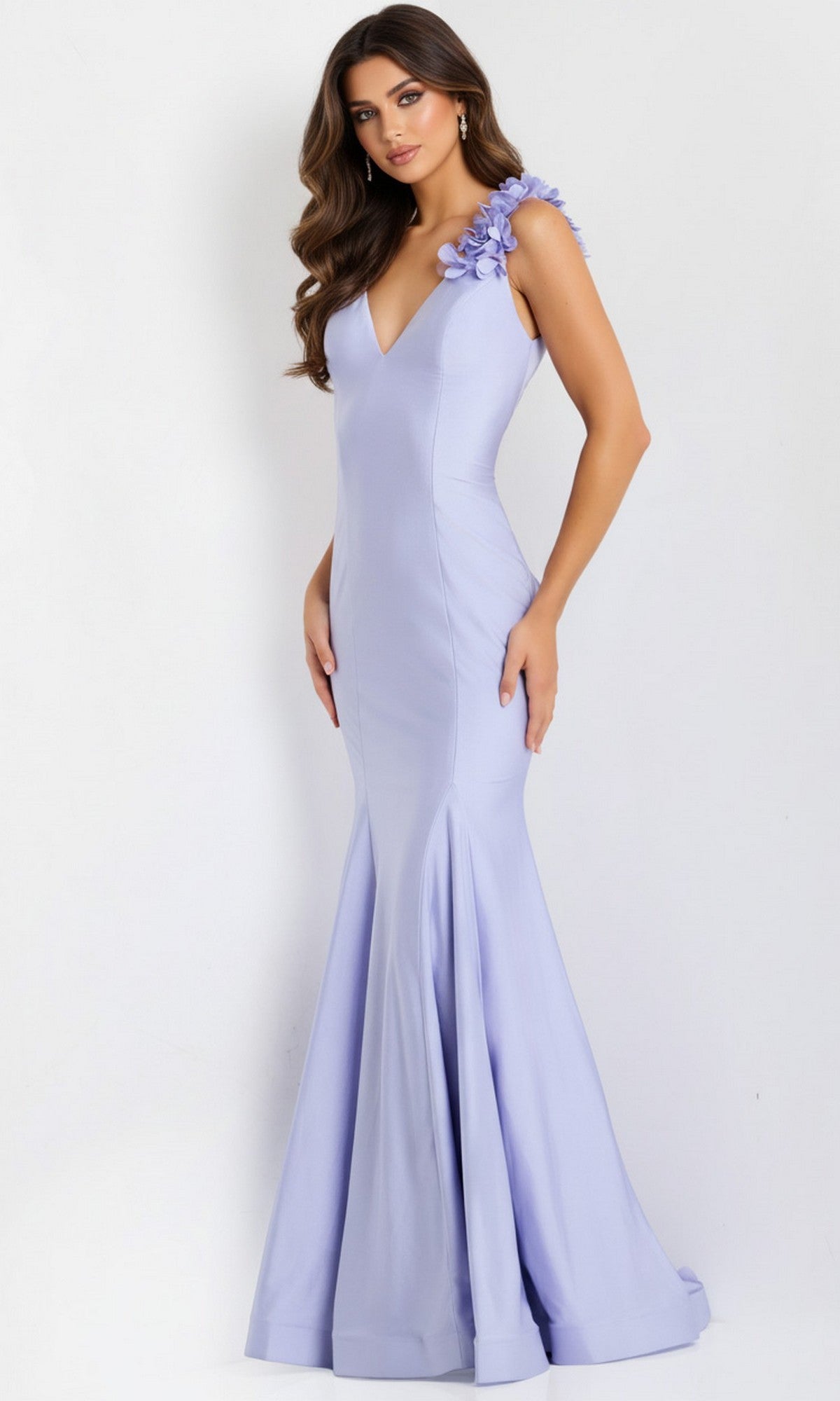 A woman stands against a white background wearing the Jovani 48120 long lilac prom dress, a floor-length mermaid style with 3D floral appliques on one shoulder.